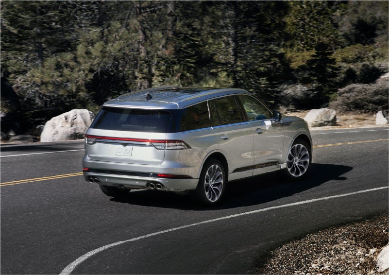 A 2023 Lincoln Aviator® Grand Touring model is shown being driven on a tight turn of a mountain road | Eby Lincoln in Goshen IN