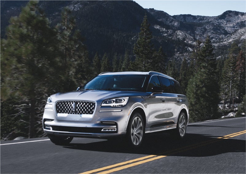 A 2023 Lincoln Aviator® Grand Touring SUV being driven on a winding road to demonstrate the capabilities of all-wheel drive | Eby Lincoln in Goshen IN