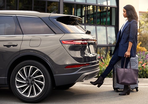 A woman with her hands full uses her foot to activate the hands-free liftgate. | Eby Lincoln in Goshen IN