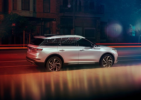 A 2023 Lincoln Corsair® SUV is shown parked in the city at night. | Eby Lincoln in Goshen IN