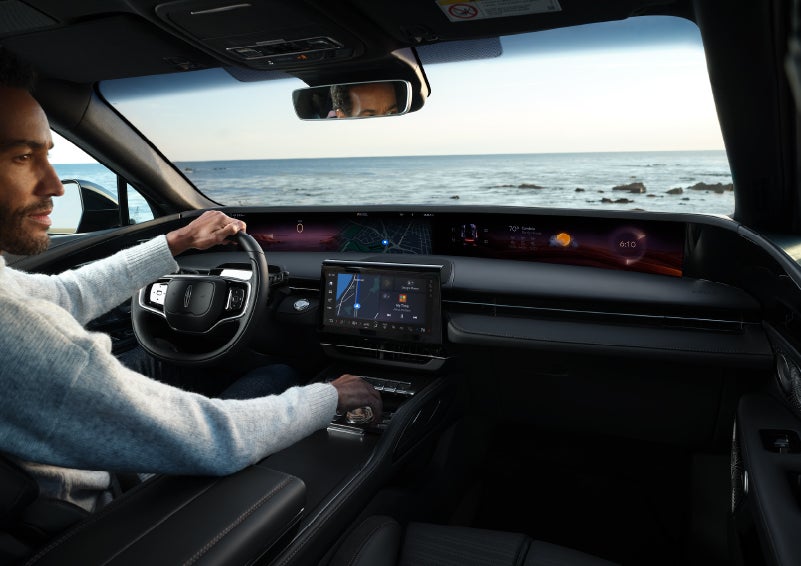 A driver of a parked 2024 Lincoln Nautilus® SUV takes a relaxing moment at a seaside overlook while inside his Nautilus. | Eby Lincoln in Goshen IN